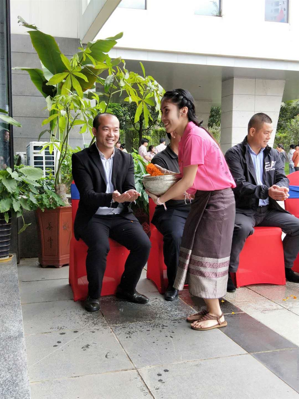老撾駐廣西留學(xué)生代表將浸有花瓣的香水灑客人的手上，表示對(duì)嘉賓的美好祝福（圖一）