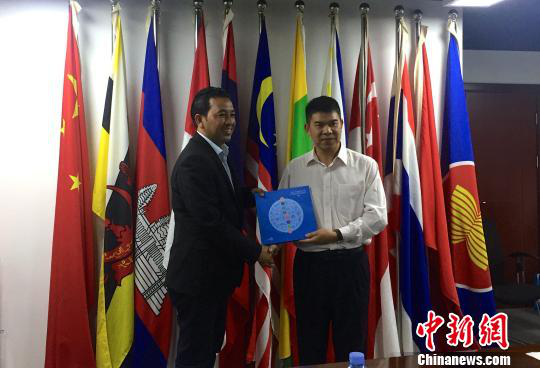 中國(guó)—東盟博覽會(huì)秘書處副秘書長(zhǎng)黃平西（右）與柬埔寨新聞部新聞與傳播總司副總司長(zhǎng)春占皮侖（左）互贈(zèng)禮物。