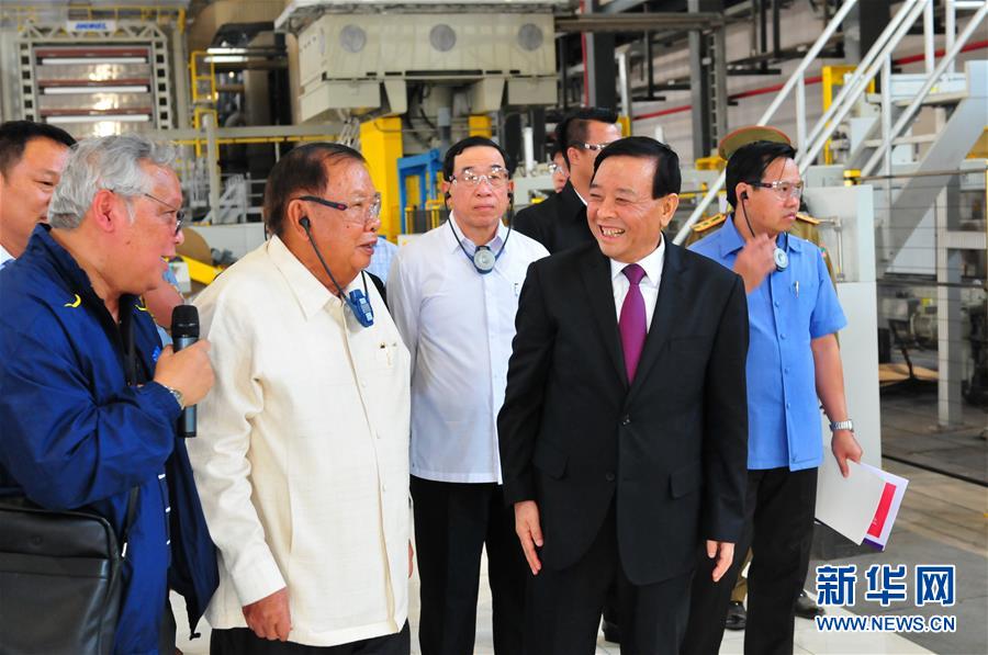 3月10日，在老撾沙灣拿吉省車邦縣，老撾人民革命黨中央總書記、國家主席本揚（左二）在山東太陽紙業(yè)股份有限公司董事長李洪信（右二）的陪同下視察公司。 新華社記者章建華攝